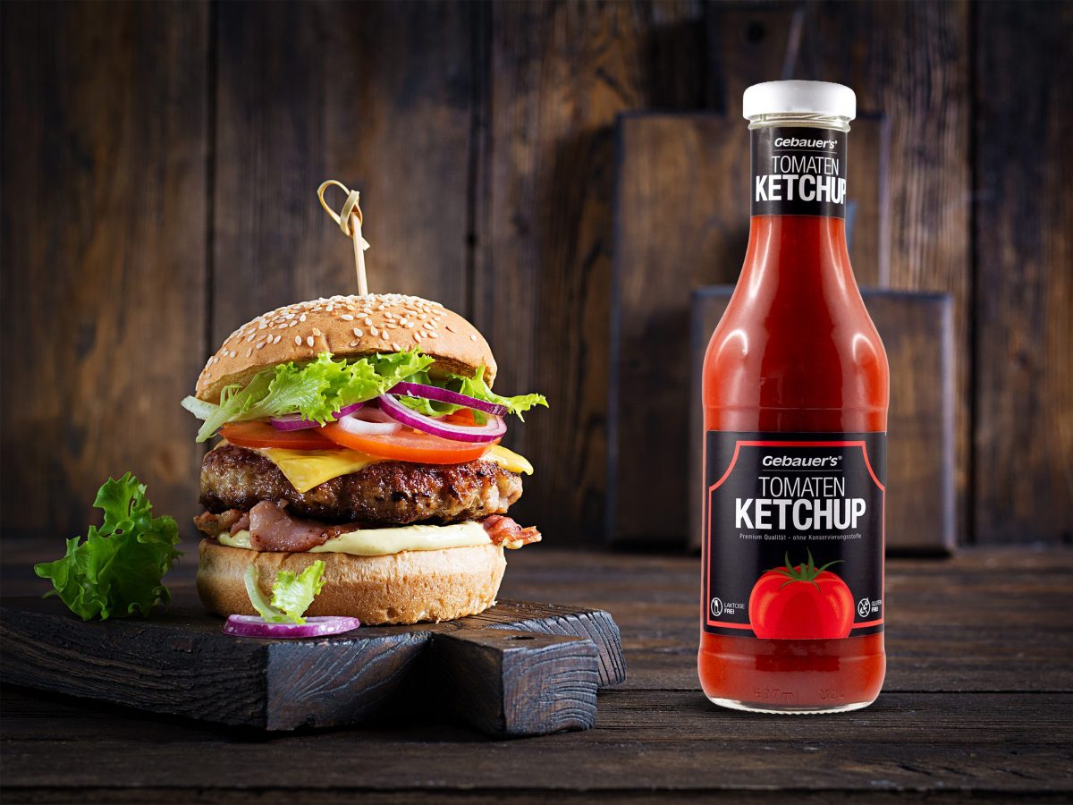 Eine Flasche Gebauer's Ketchup steht rechts neben einem Burger